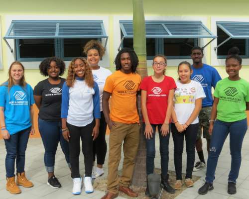 Group of smiling young adults in front of tree